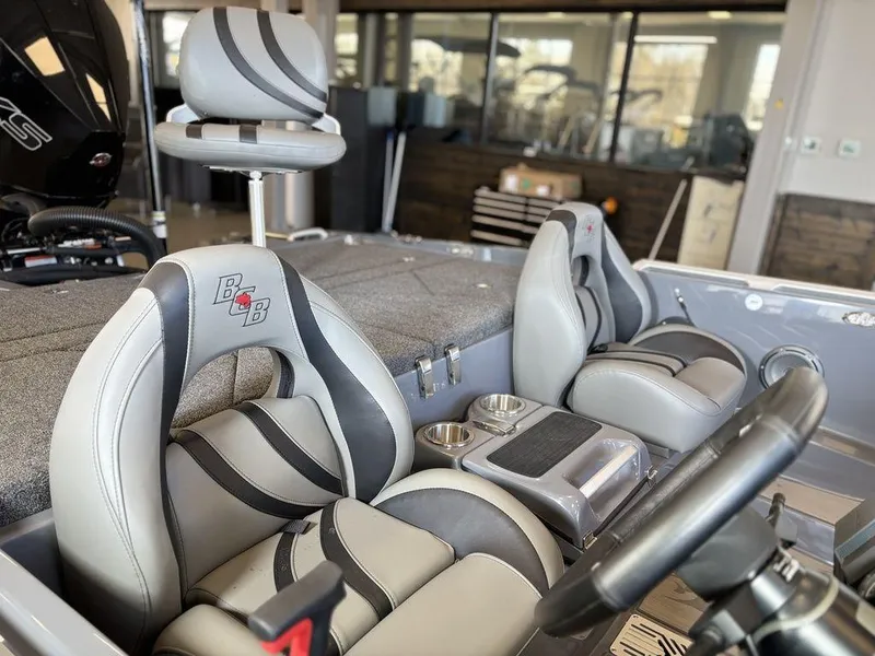 Slide: The Image of 2024 Bass Cat Caracal STS boat interior with gray and black seating, steering wheel, and console. - 6