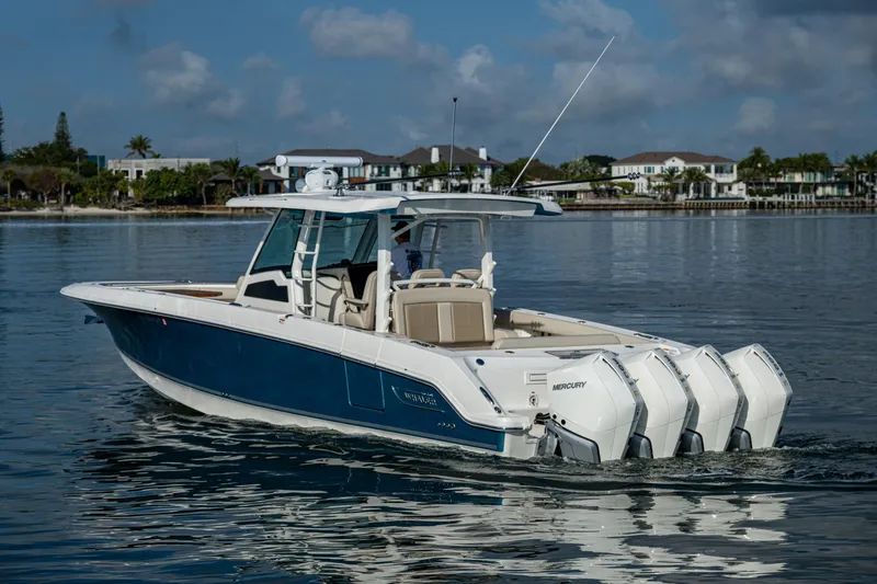 Slide: The Image of 2024 Boston Whaler 380 Outrage boat on calm water, showcasing sleek design and powerful engines. - 11