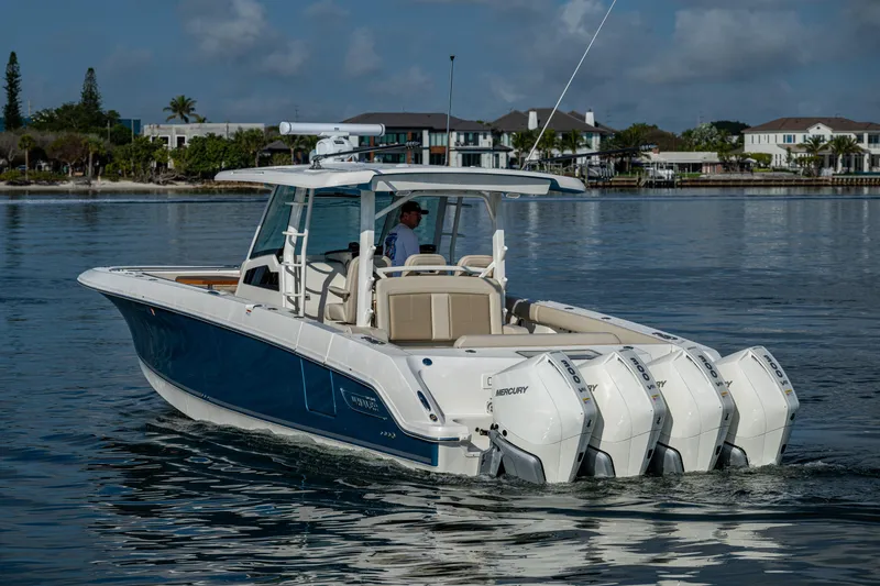 Slide: The Image of 2024 Boston Whaler 380 Outrage boat cruising on calm water, featuring powerful engines. - 12