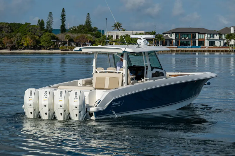 Slide: The Image of 2024 Boston Whaler 380 Outrage boat with four engines on calm water. - 17