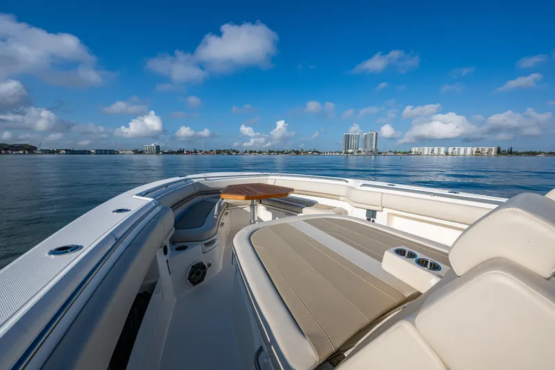 Slide: The Image of 2024 Boston Whaler 380 Outrage boat, luxurious seating, scenic waterfront view. - 22
