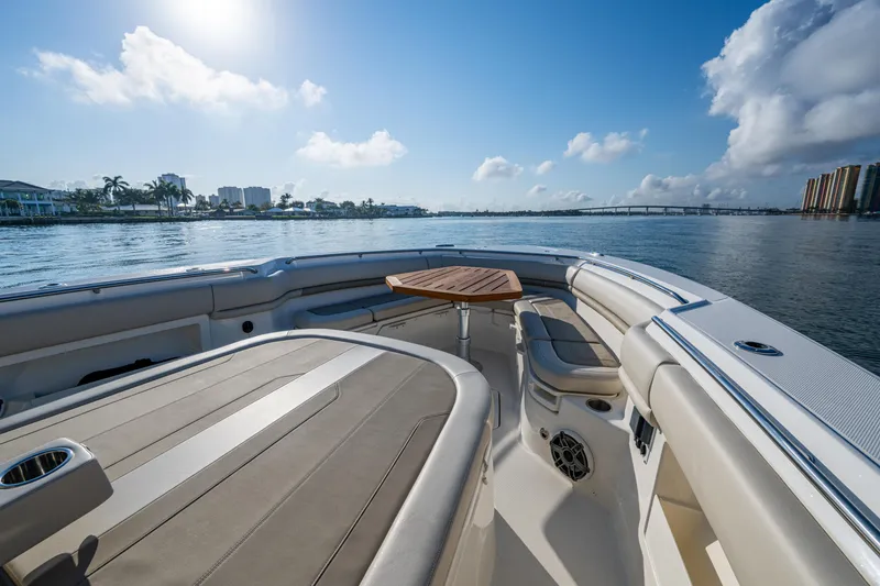 Slide: The Image of 2024 Boston Whaler 380 Outrage boat interior with seating and table, on a sunny day. - 24
