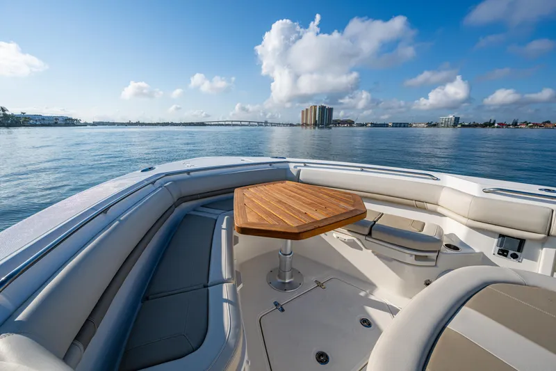 Slide: The Image of 2024 Boston Whaler 380 Outrage boat interior with wooden table, ocean view. - 26