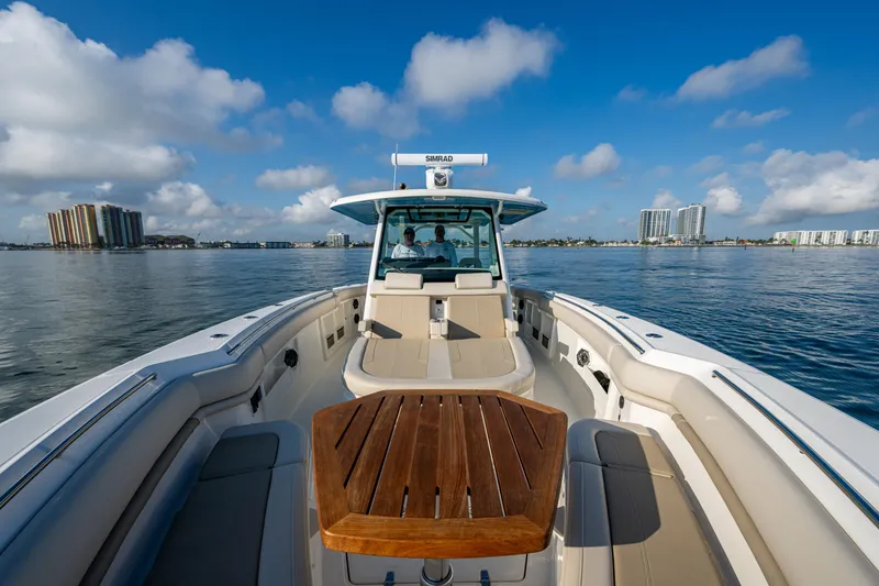 Slide: The Image of 2024 Boston Whaler 380 Outrage on calm water, showcasing spacious deck and seating. - 28