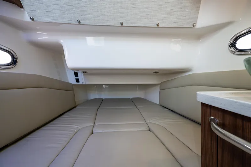 Slide: The Image of 2024 Boston Whaler 380 Outrage cabin interior with beige seating and modern design. - 32