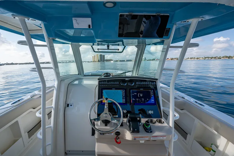 Slide: The Image of 2024 Boston Whaler 380 Outrage helm with advanced navigation systems on calm waters. - 40