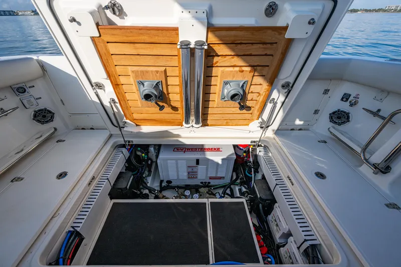 Slide: The Image of 2024 Boston Whaler 380 Outrage engine compartment with open hatch, showcasing equipment and storage. - 49