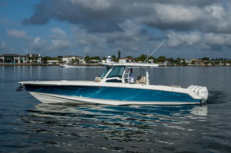 Slide: The Image of 2024 Boston Whaler 380 Outrage boat on calm water, under a cloudy sky. - 7