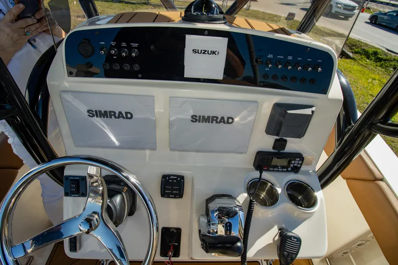 Slide: The Image of 2021 Pioneer 202 Islander boat dashboard with Simrad displays and Suzuki controls. - 13