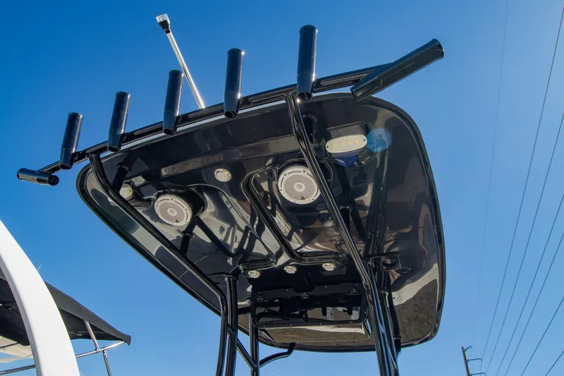 Slide: The Image of 2021 Pioneer 202 Islander boat's T-top with rod holders against blue sky. - 17