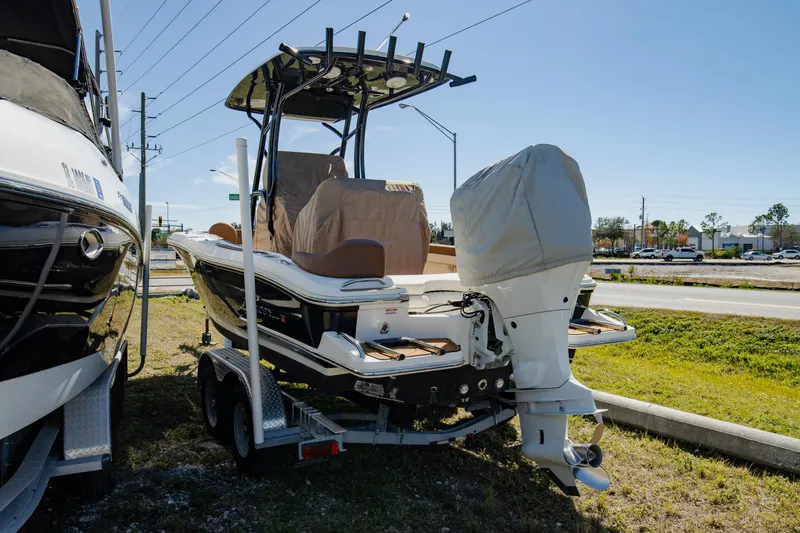 Slide: The Image of 2021 Pioneer 202 Islander boat on trailer, parked outdoors, with covered outboard motor. - 27