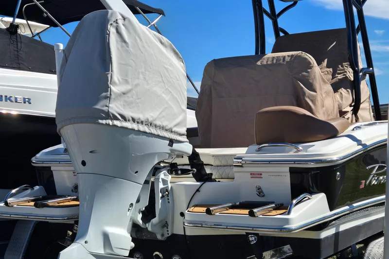 Slide: The Image of 2021 Pioneer 202 Islander boat with covered engine and seating, docked under clear blue sky. - 3