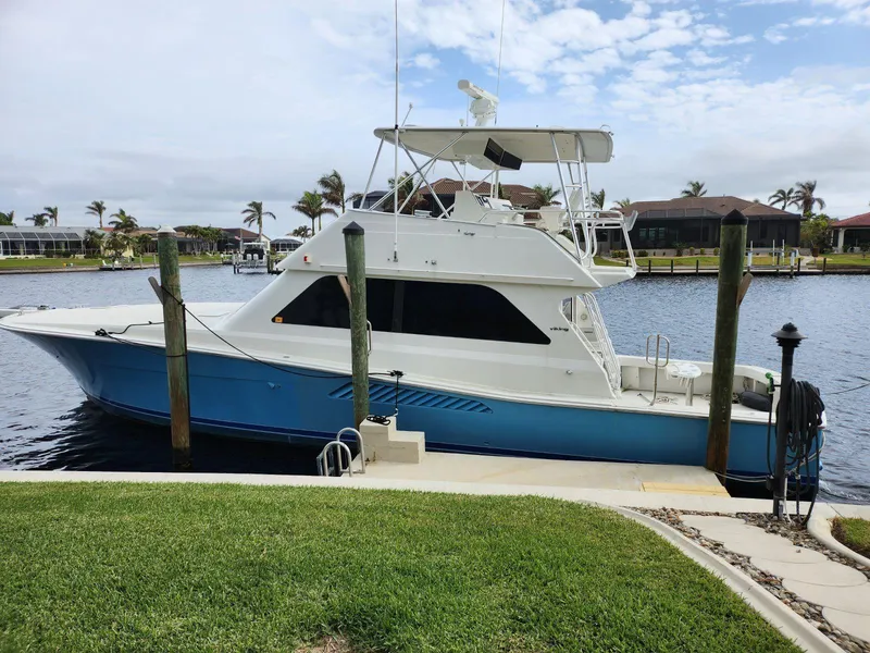 The Image of 1999 Viking 50 Convertible yacht docked by waterfront homes. - 0