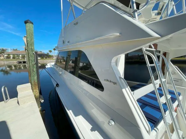 Slide: The Image of 1999 Viking 50 Convertible yacht docked, showcasing sleek design and spacious deck. - 10