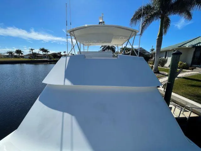 Slide: The Image of 1999 Viking 50 Convertible yacht docked by palm trees under clear blue sky. - 18