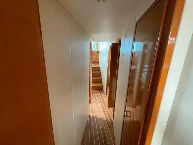 Slide: The Image of Hallway inside 1999 Viking 50 Convertible yacht, featuring wooden doors and striped flooring. - 27