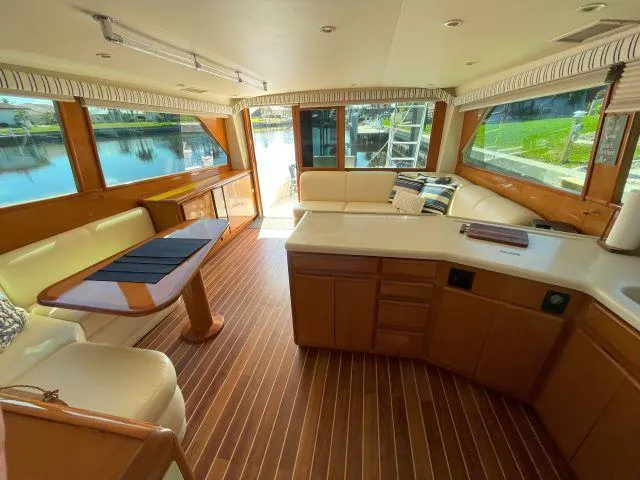 Slide: The Image of Interior of 1999 Viking 50 Convertible yacht with wood flooring and spacious seating area. - 28