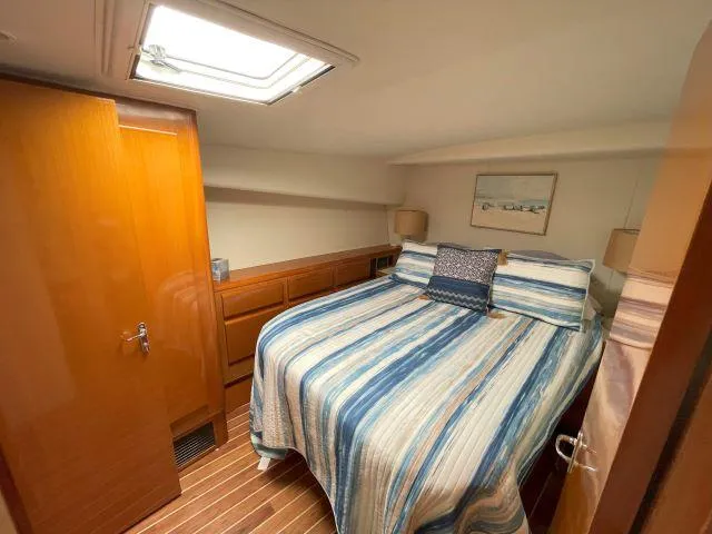 Slide: The Image of Cozy bedroom in 1999 Viking 50 Convertible yacht with striped bedding and wooden accents. - 38