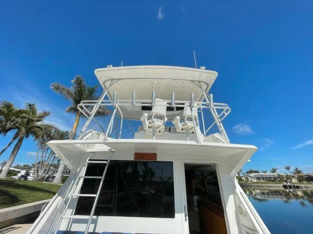 Slide: The Image of 1999 Viking 50 Convertible yacht docked under clear blue sky. - 4