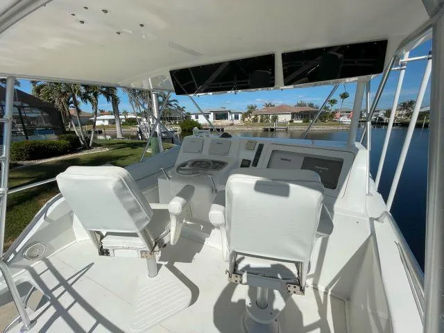 Slide: The Image of 1999 Viking 50 Convertible yacht helm with dual white captain chairs and control panel. - 6
