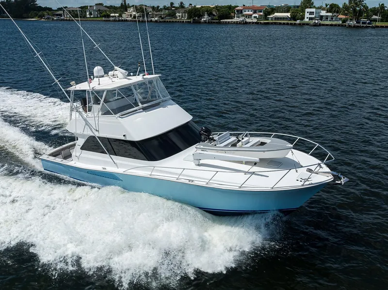 Slide: The Image of 2000 Viking 50 Convertible yacht cruising on a calm waterway. - 2