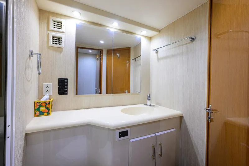 Slide: The Image of Bathroom interior of 2000 Viking 50 Convertible yacht, featuring a sleek vanity and mirror. - 22