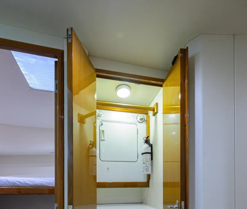 Slide: The Image of Interior of 2000 Viking 50 Convertible yacht with open wooden doors and storage compartment. - 25