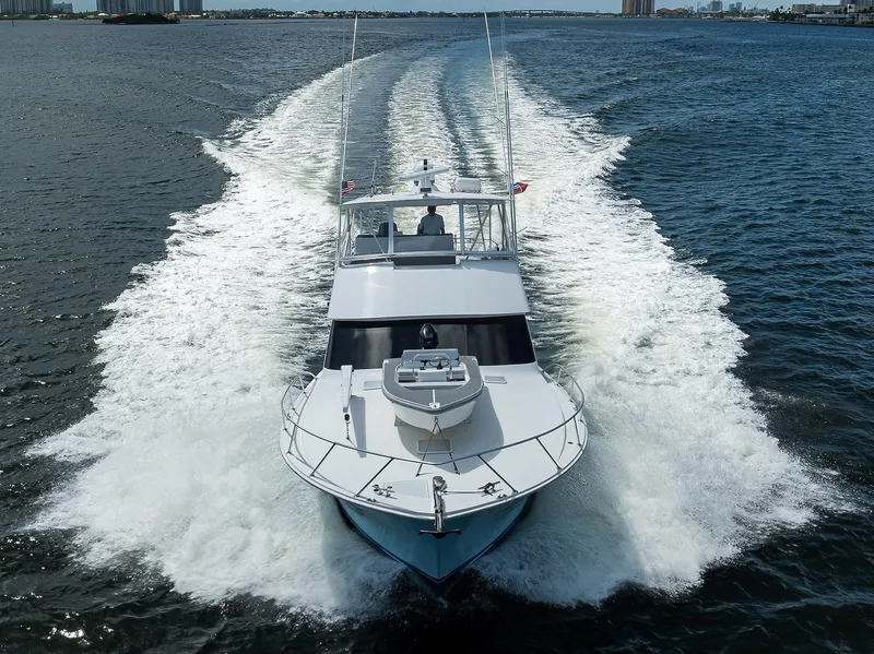 Slide: The Image of 2000 Viking 50 Convertible yacht cruising on open water, creating a dynamic wake. - 27