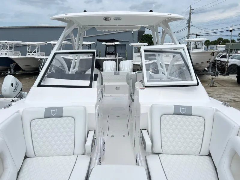 Slide: The Image of 2025 Sea Fox 288 Traveler boat with white seating and dual consoles in a marina. - 18