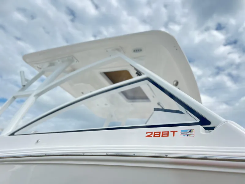 Slide: The Image of 2025 Sea Fox 288 Traveler boat against a cloudy sky, showcasing sleek design and branding. - 2