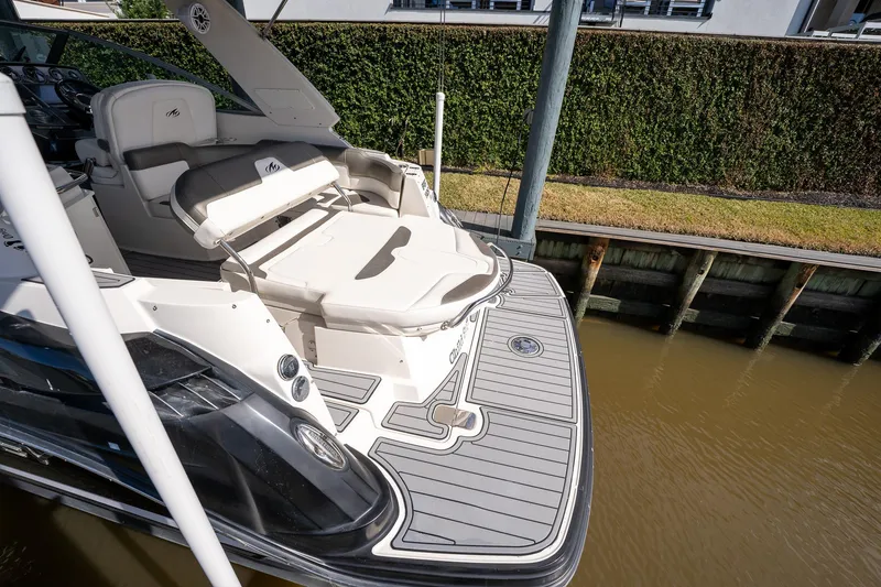 Slide: The Image of 2014 Monterey 295 Sport Yacht with spacious deck and seating, docked by a canal. - 10