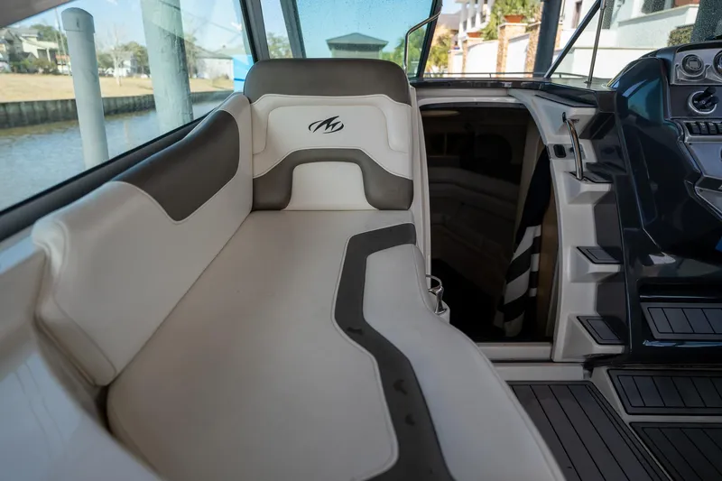 Slide: The Image of 2014 Monterey 295 Sport Yacht interior with cushioned seating and helm. - 16