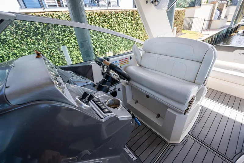 Slide: The Image of 2014 Monterey 295 Sport Yacht helm with white seating and modern controls. - 20