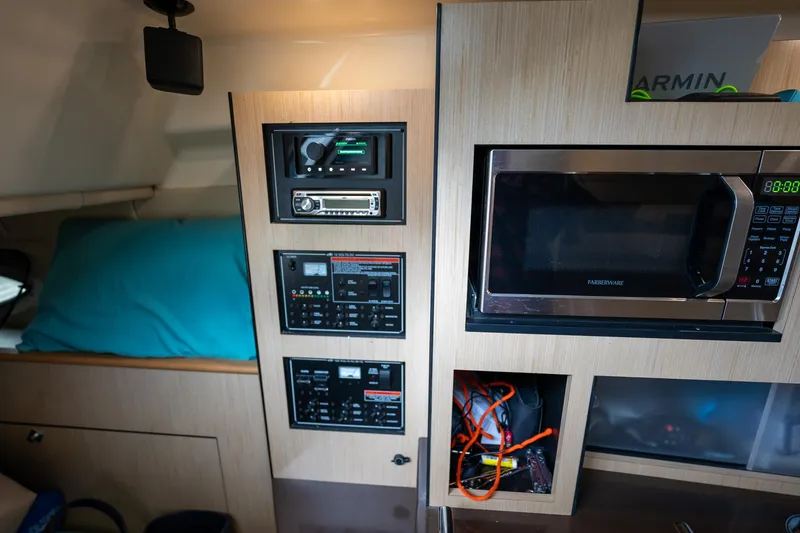 Slide: The Image of Interior of 2014 Monterey 295 Sport Yacht with control panels and microwave. - 27
