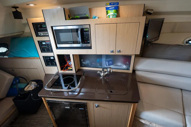 Slide: The Image of Compact kitchen area in a 2014 Monterey 295 Sport Yacht with microwave and sink. - 28