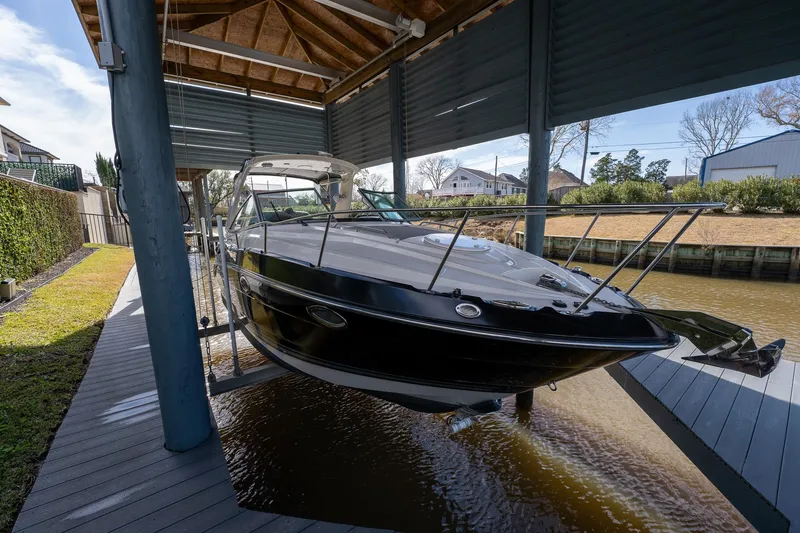 Slide: The Image of 2014 Monterey 295 Sport Yacht docked under a covered boathouse. - 3