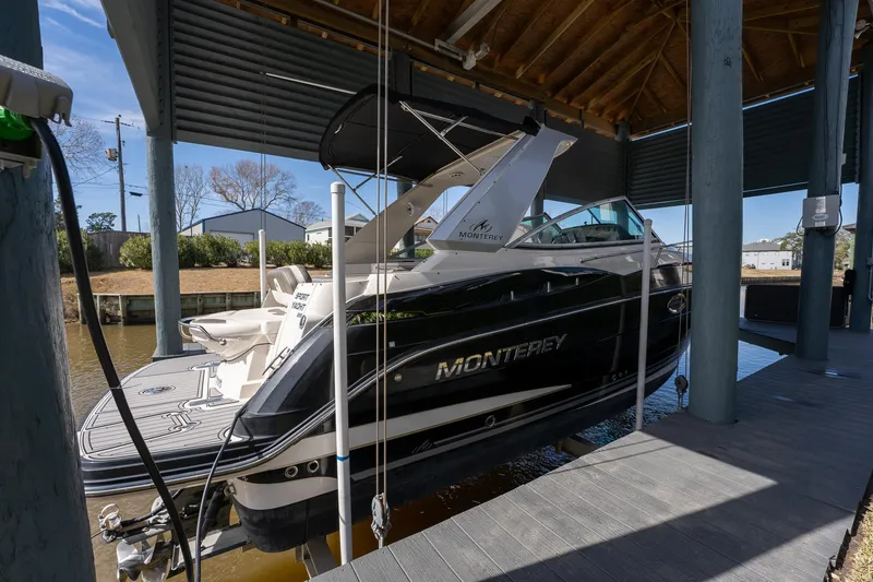 Slide: The Image of 2014 Monterey 295 Sport Yacht docked under a covered marina. - 6