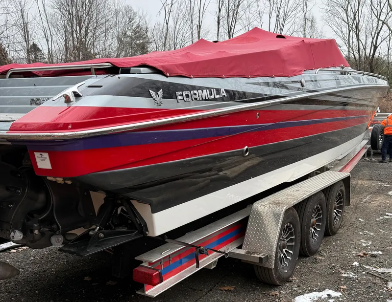 Slide: The Image of 2014 Formula 382 FASTech boat on trailer, red and black design, covered, parked outdoors. - 11