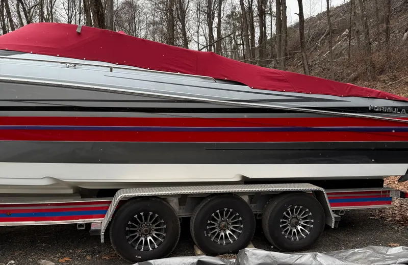 Slide: The Image of 2014 Formula 382 FASTech boat with red cover on a trailer in wooded area. - 8