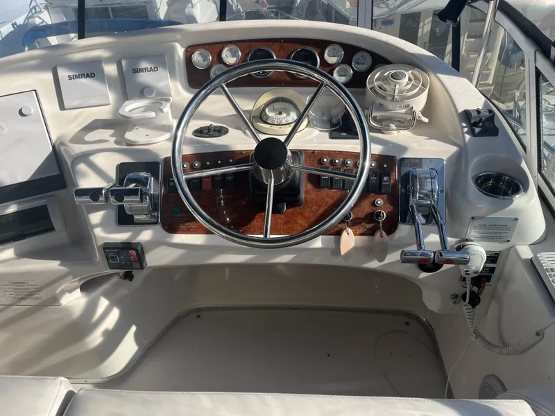 Slide: The Image of 2003 Silverton 410 Sport Bridge helm with steering wheel, controls, and navigation instruments. - 12