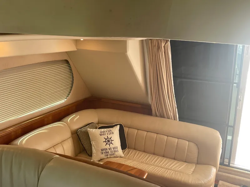 Slide: The Image of Interior of 2003 Silverton 410 Sport Bridge with beige leather seating and nautical-themed pillow. - 14