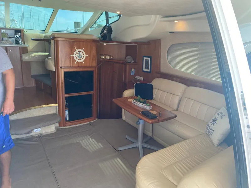 Slide: The Image of Interior of a 2003 Silverton 410 Sport Bridge yacht with beige seating and wooden accents. - 16