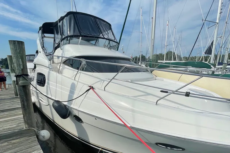 Slide: The Image of 2003 Silverton 410 Sport Bridge yacht docked at a marina under a clear sky. - 19