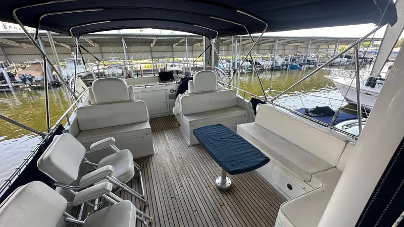 Slide: The Image of 1987 Grand Banks 46 Classic yacht interior with seating and table, docked in a marina. - 15