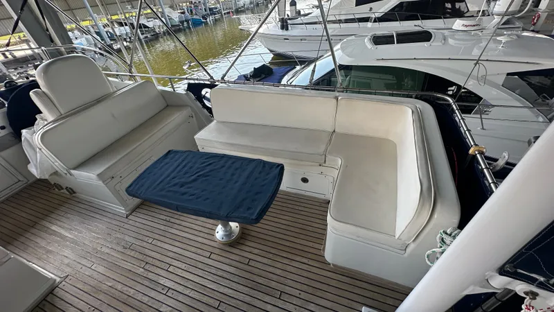 Slide: The Image of 1987 Grand Banks 46 Classic yacht deck with cushioned seating and table. - 16