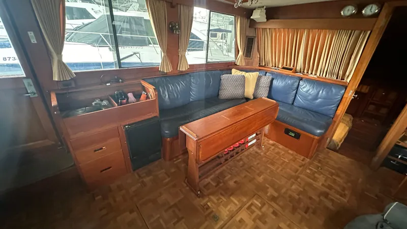 Slide: The Image of Interior of 1987 Grand Banks 46 Classic yacht with blue seating and wooden table. - 26