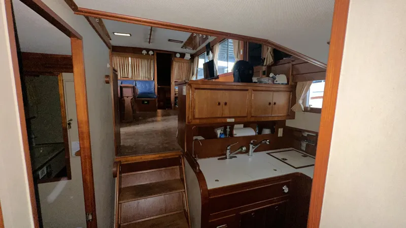 Slide: The Image of Interior of 1987 Grand Banks 46 Classic yacht, featuring wooden cabinetry and compact kitchen area. - 29