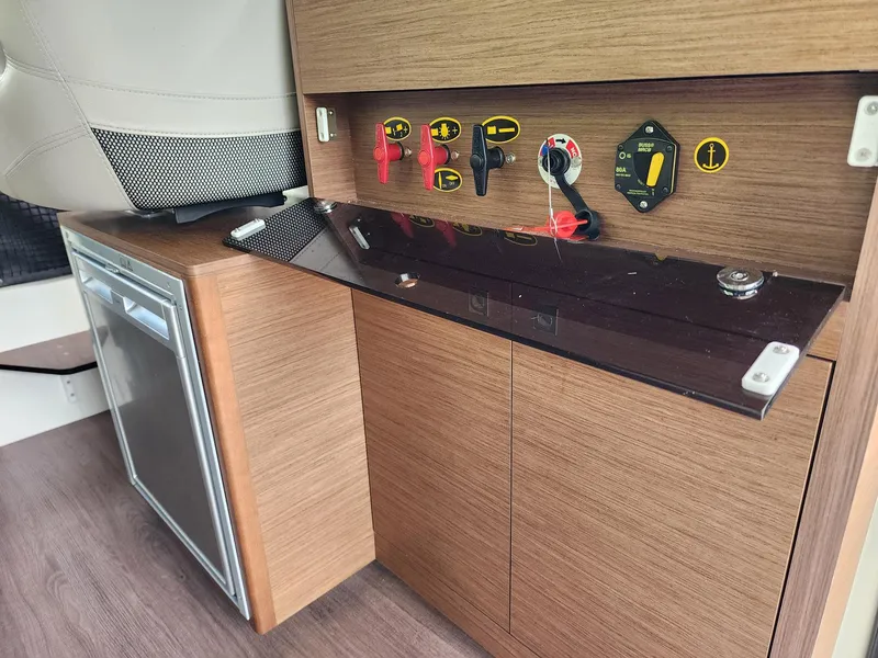 Slide: The Image of 2023 Jeanneau NC Sport 895 interior controls and storage area. - 10