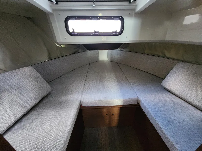 Slide: The Image of 2023 Jeanneau NC Sport 895 cabin interior with cushioned seating and window. - 22