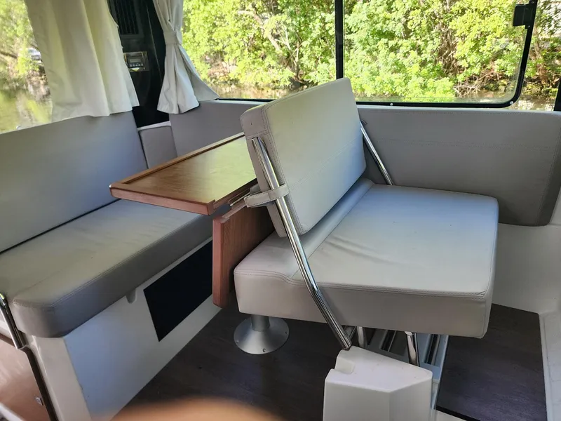 Slide: The Image of Interior of 2023 Jeanneau NC Sport 895, featuring a cozy seating area with a wooden table. - 27